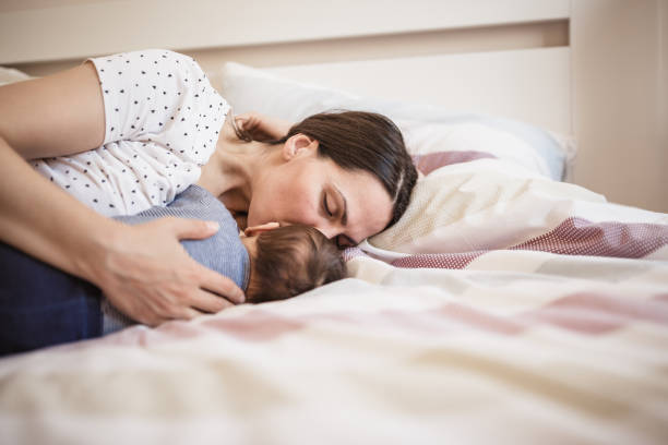 istock Smiling mother with her newborn son in bed 1152567700