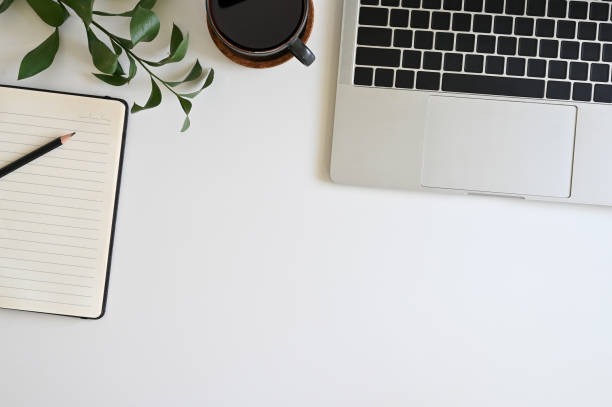 istock Office desk top view table with laptop, coffee, plant, notebook and pencil 1152569097