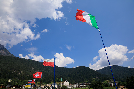 International flags fluttering in the wind. Summer landscape. Beautiful view of Auronzo di Cadore,  mountain in Dolomites,  Northern Italy. Summer on the mountain