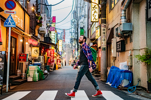 Retrato del hombre caminando en el cruce de cebra en la calle Tokyo photo