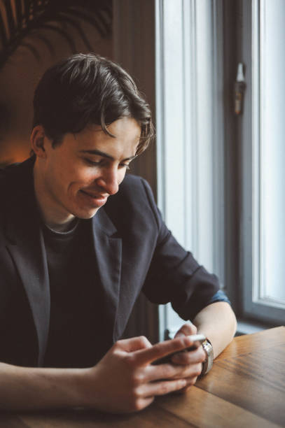 istock Young man using phone, sitting in the cafe 1152577152