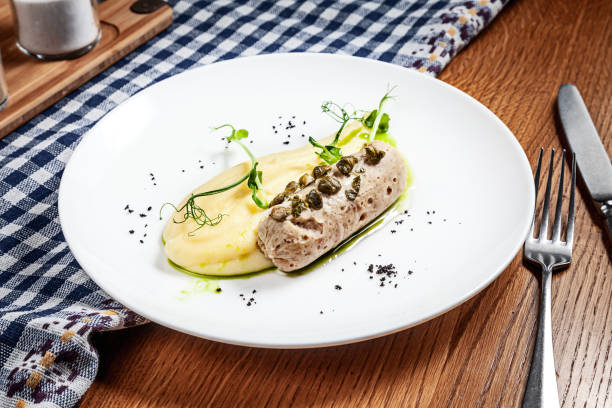 istock Close up view on sausage from fish with mashed potato and microgreen on white plate on wooden background. Copy space. Concept of modern cuisine. Picture for recipe or menu 1152580258