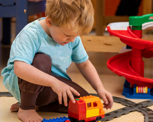 istock A cute little boy playing indoors with a train 1152580418