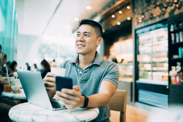 istock Man drinking coffee and working on laptop in cafe 1152581340