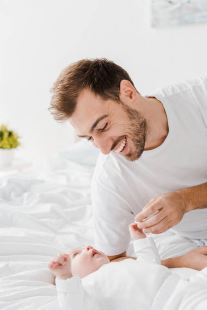 istock Happy young father lying on bed with baby 1152582952