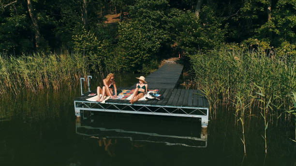 istock Friends relaxing on a lake pier. Summer activities 1152586186
