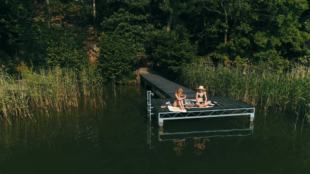 istock Friends relaxing on a lake pier. Summer activities 1152586196