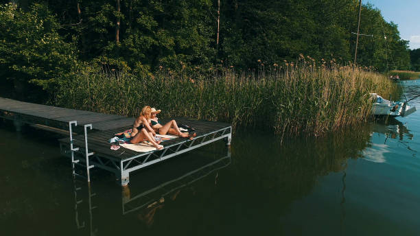 istock Friends relaxing on a lake pier. Summer activities 1152586592