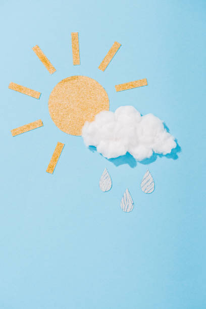 istock paper sun and cotton candy cloud with glitter raindrops on blue 1152587799