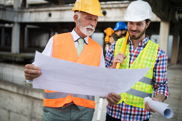 istock Confident team of architects and engineers working together on construction site 1152589183