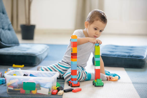 istock Little boy sitting on bedroom floor and playing 1152593903