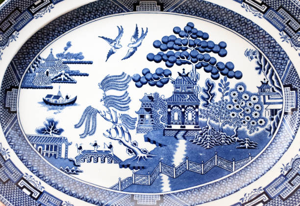 盛り合わせを提供するアンティークビクトリア朝の伝統的な柳模様のデザイン - plate china antique blue ストックフォトと画像