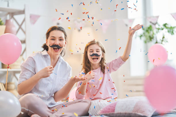 party at home Funny time. Mom and her child daughter are playing at home. Cute girls are holding paper mustache on stick. Family holiday and togetherness. barbel stock pictures, royalty-free photos & images