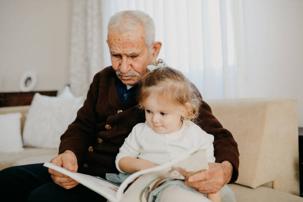 istock Grandfather reading with his granddaughter 1152598020