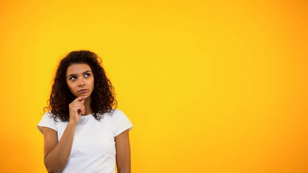 istock Pensive black girl touching chin and looking up, choosing between options 1152598267