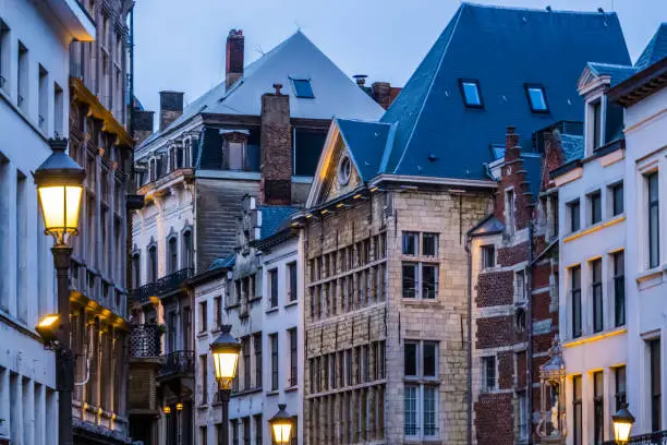 Photo of old classical city architecture with lighted lampposts in the city of antwerp, antwerpen, Belgium