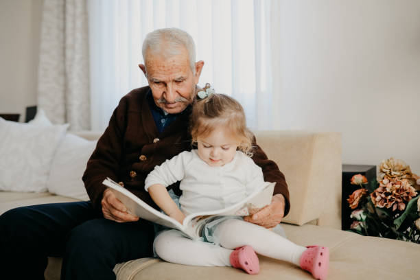 istock Grandfather reading with his granddaughter 1152598617