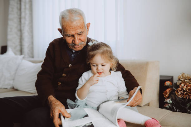 istock Grandfather reading with his granddaughter 1152598816