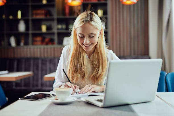istock Businesswoman writing in agends her tasks while sitting in cafe. 1152599896