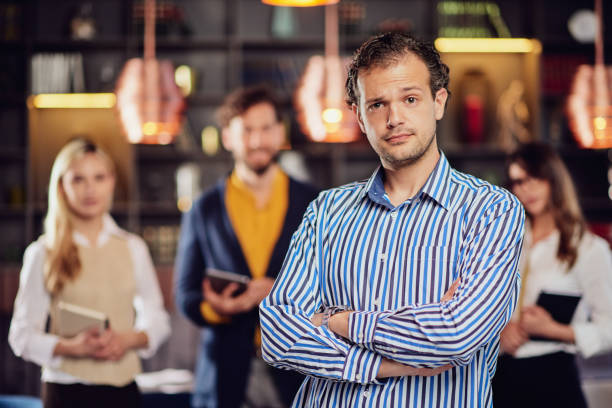 istock Businessman posing in cafe. In background his colleagues standing. 1152600384