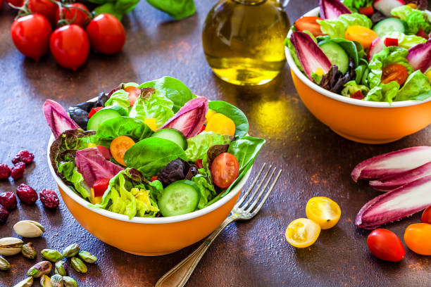 istock Healthy eating: two fresh salad bowls ready to eat on brown table 1152601346