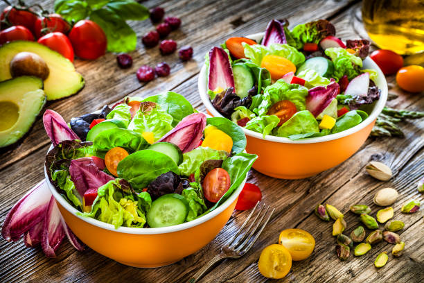 istock Healthy eating: two fresh salad bowls ready to eat on wooden table 1152601362