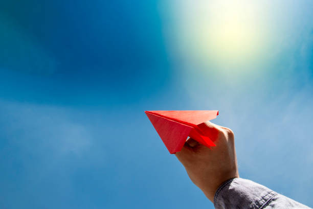 istock Human hand holding red paper airplane aim 1152602530