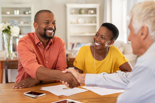 Man shaking hands with insurance agent Mature black husband shaking hands with senior agent on taking loan. Happy african couple sealing with handshake a contract with financial advisor for investment. Man making sale purchase deal concluding with a handshake with estate agent. salesman photos stock pictures, royalty-free photos & images