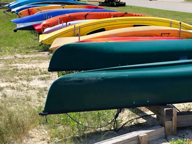 A colorful assortment of canoes and kayaks arranged along a waterway. This photo was taken at Beaufort, North Carolina.