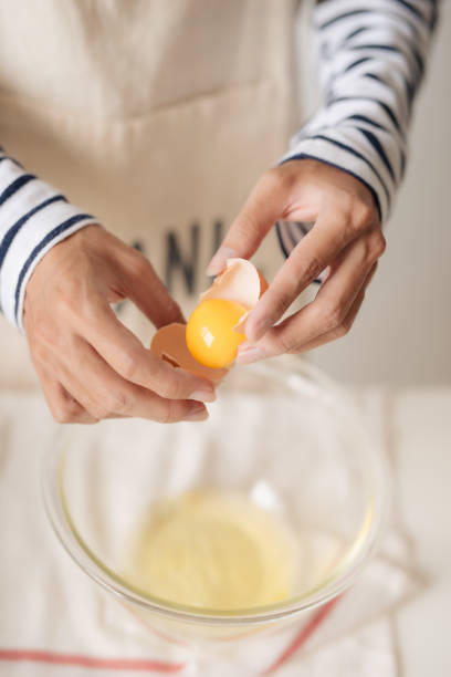 istock broken egg in hands with separated yolk closeup 1152608602