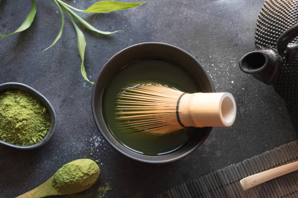 istock Ceremony green matcha tea and bamboo whisk on black table. Top view. Space for text. 1152608683