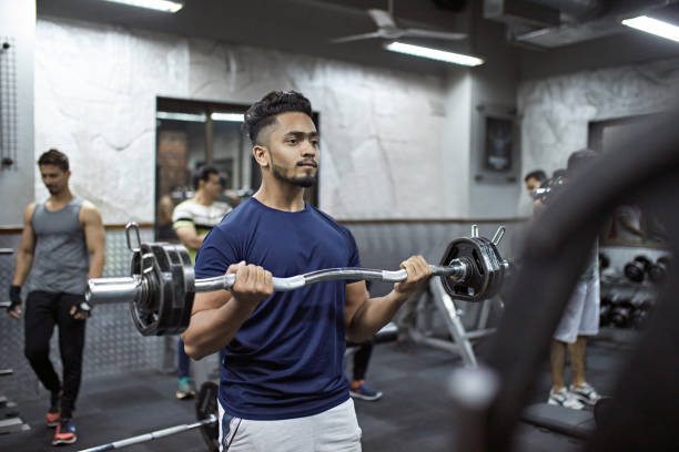 istock Confident young man lifting barbell at gym 1152611085