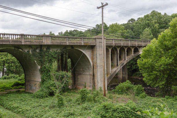 istock Vintage stone block bridge over a river surrounded by lush vegetation 1152611328