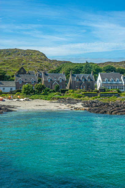 бирюзовый залив с традиционными коттеджами у пляжа на острове иона на гебридских островах шотландии - iona стоковые фото и изображения
