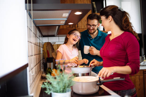istock Parents and daughter in the kitchen preparing spaghetti together 1152611455
