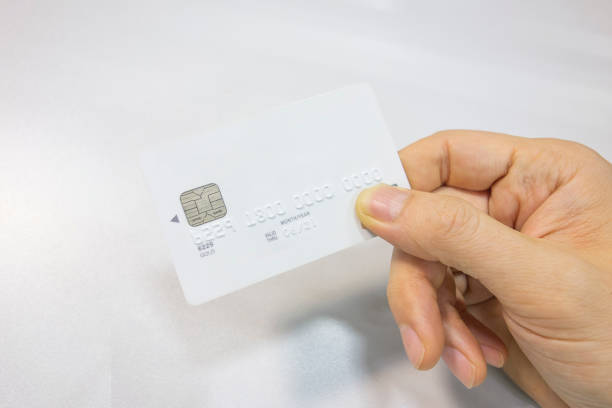 istock A white bank card in hand on the desk 1152611563