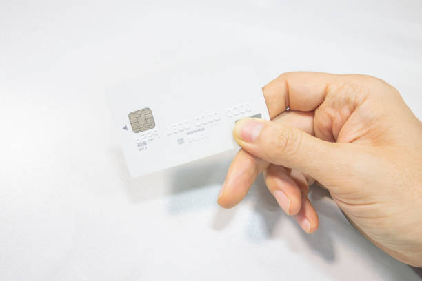 istock A white bank card in hand on the desk 1152611771