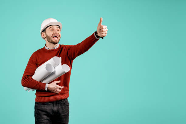 istock Attractive young handsome bearded engineer or constructor man in casual outfit show ok gesture over cyan background. Architecture and Renovation concept. 1152611781