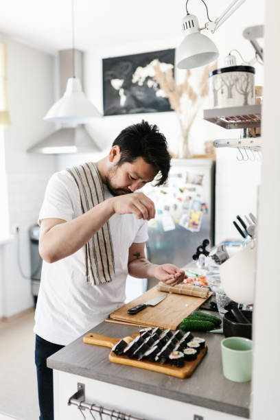 istock Japanese man sprinkling sesame seeds on sushi 1152612689