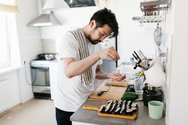 istock Japanese man sprinkling sesame seeds on sushi 1152612699
