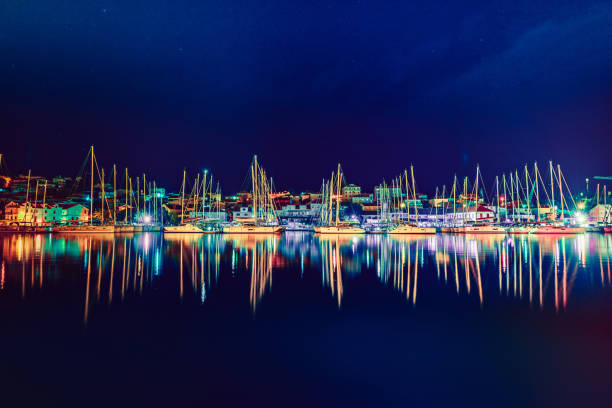 Sailboats in the harbor at clear night.
