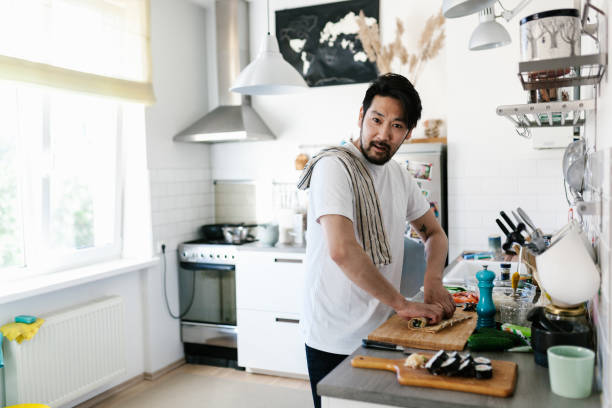istock Japanese man rolling maki sushi and looking at camera 1152612778