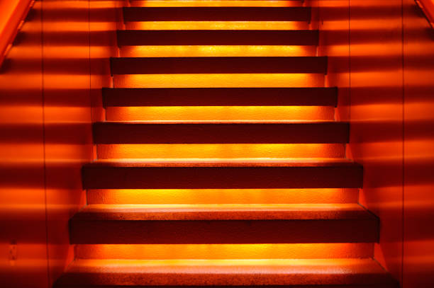 istock Stairway with orange and yellow lights along steps creating a vector illustration 1152613022
