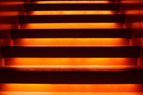 istock Stairway with orange and yellow lights along steps creating a vector illustration 1152613116