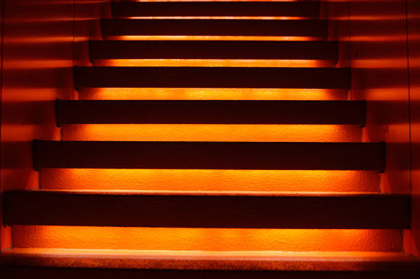 Stairway with orange and yellow lights along steps creating a vector illustration in darkness