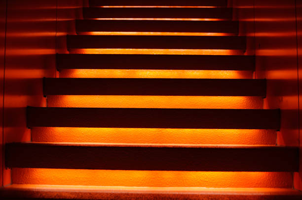 istock Stairway with orange and yellow lights along steps creating a vector illustration 1152613874