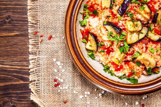 istock Couscous and vegetables on wooden table 1152614501