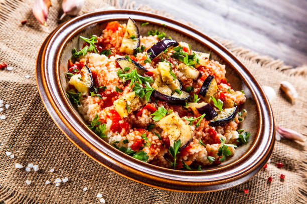 Couscous and vegetables on wooden table
