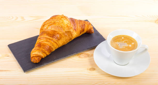 istock A croissant and a coffee on a wooden surface 1152615610