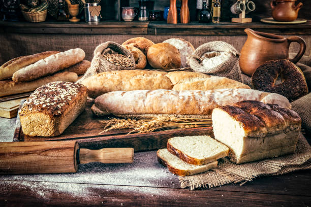 padaria artesanal: pão fresco misturado, rolos e ingredientes em uma cozinha rústica - bread soda bread baked sesame - fotografias e filmes do acervo